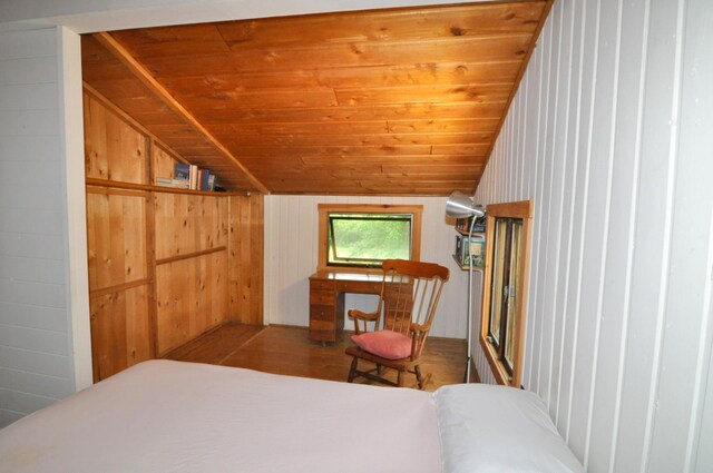 24892 277th Ave, Akeley Twp, MN 56467 - bedroom with vaulted ceiling, wood finished floors, wooden ceiling, and wood walls