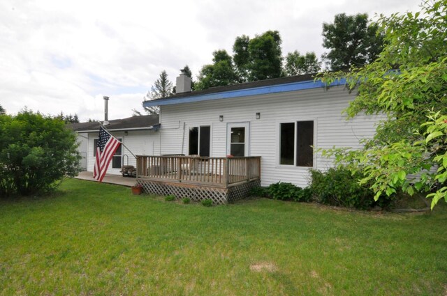 24892 277th Ave, Akeley Twp, MN 56467 - rear view of house featuring a wooden deck, a lawn, and a chimney