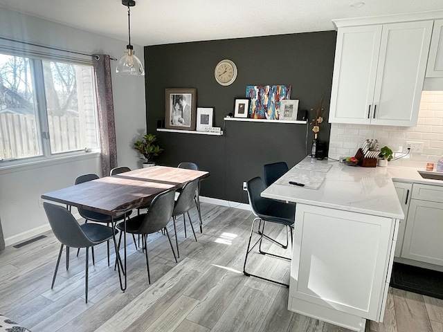 9106 Neill Lake Rd, Eden Prairie, MN 55347 - dining area featuring light wood-style flooring and baseboards