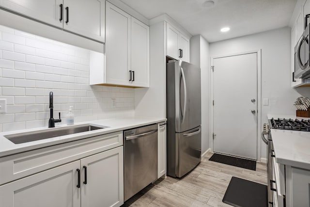 9106 Neill Lake Rd, Eden Prairie, MN 55347 - kitchen with appliances with stainless steel finishes, light wood finished floors, tasteful backsplash, light countertops, and white cabinetry