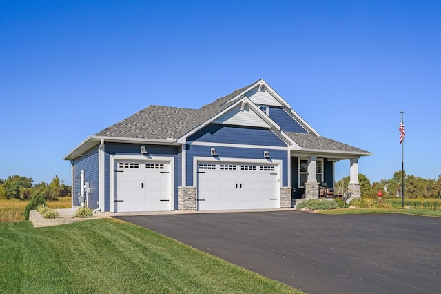 7720 242nd St, Wyoming, MN 55025 - craftsman-style home featuring a garage, asphalt driveway, a front yard, stone siding, and covered porch
