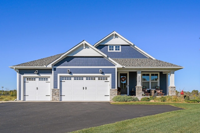 7720 242nd St, Wyoming, MN 55025 - craftsman-style home with a porch, stone siding, driveway, and a garage