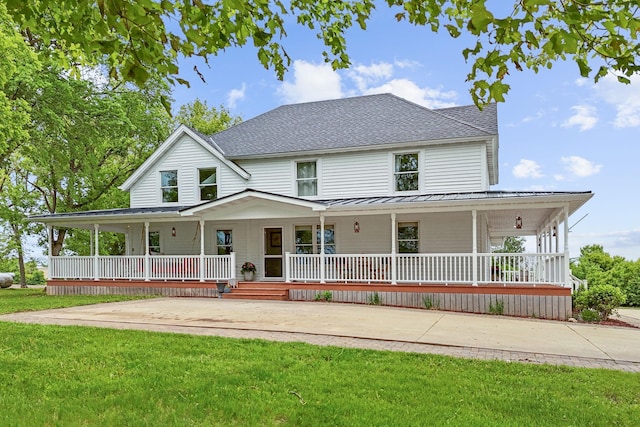27151 Aberdeen Ave, New Prague, MN 56071 - view of front facade with covered porch, a standing seam roof, a front lawn, and metal roof