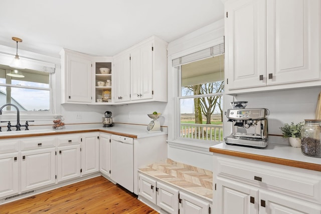 27151 Aberdeen Ave, New Prague, MN 56071 - kitchen featuring white dishwasher, a sink, light countertops, white cabinets, and decorative light fixtures