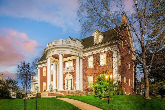 2525 2nd St, Duluth, MN 55812 - neoclassical home with a balcony, brick siding, a front lawn, and a chimney