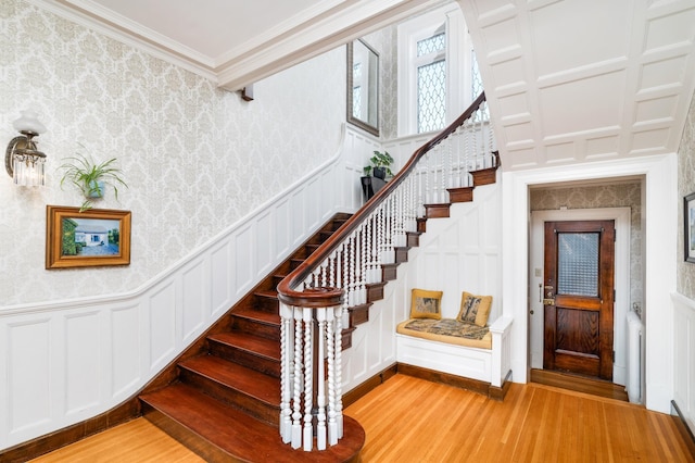 2525 2nd St, Duluth, MN 55812 - stairs featuring wood finished floors, a decorative wall, crown molding, wallpapered walls, and a wainscoted wall