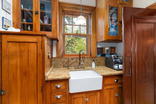 2525 2nd St, Duluth, MN 55812 - kitchen featuring a sink, brown cabinetry, paneled built in fridge, glass insert cabinets, and decorative light fixtures