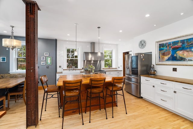 2525 2nd St, Duluth, MN 55812 - kitchen featuring ventilation hood, stainless steel fridge with ice dispenser, wood counters, light wood finished floors, and white cabinetry