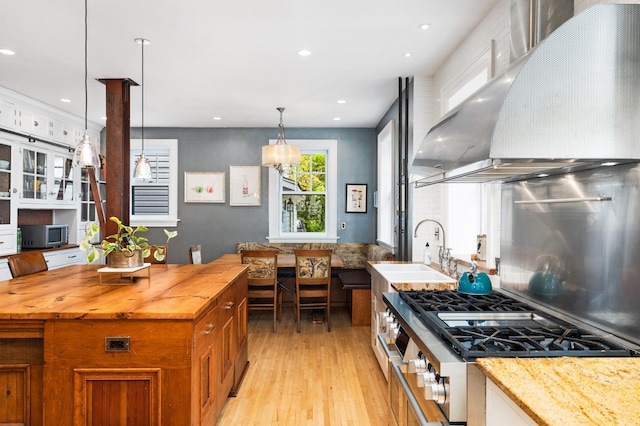 2525 2nd St, Duluth, MN 55812 - kitchen with wall chimney range hood, a sink, butcher block counters, stovetop, and light wood-style floors