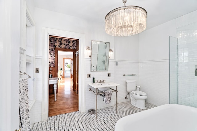 2525 2nd St, Duluth, MN 55812 - bathroom featuring a freestanding tub, a chandelier, tile patterned floors, and toilet