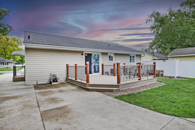 1821 4th Ave NE, Austin, MN 55912 - back of property at dusk featuring a patio, a wooden deck, and a shingled roof