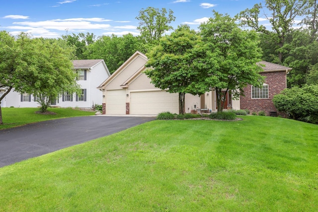 14925 Hillside Trl, Savage, MN 55378 - view of front of home featuring a garage, asphalt driveway, brick siding, and a front lawn