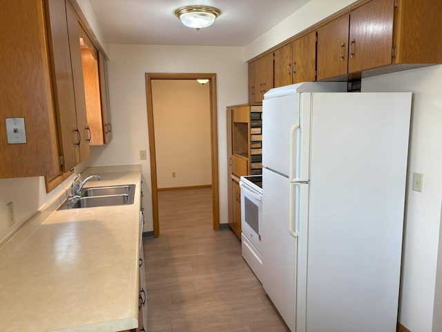 2220 23rd St NW, Rochester, MN 55901 - kitchen featuring white appliances, a sink, light wood finished floors, light countertops, and brown cabinets
