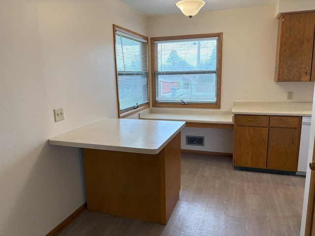 2220 23rd St NW, Rochester, MN 55901 - kitchen with light countertops, brown cabinetry, a peninsula, baseboards, and white dishwasher