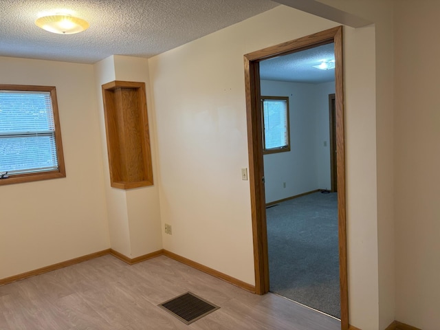 2220 23rd St NW, Rochester, MN 55901 - empty room featuring a textured ceiling, light wood-type flooring, and baseboards