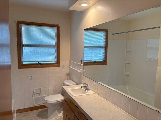 2220 23rd St NW, Rochester, MN 55901 - full bathroom with toilet, healthy amount of natural light, vanity, bathtub / shower combination, and tile walls