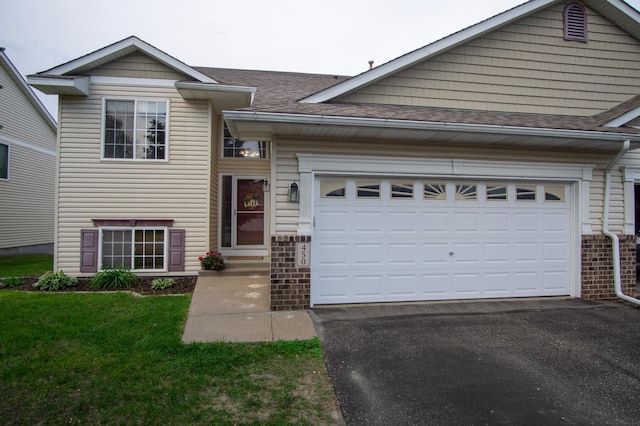 450 Meadow Ln, Somerset, WI 54025 - view of front of home featuring asphalt driveway, a garage, a shingled roof, and a front lawn