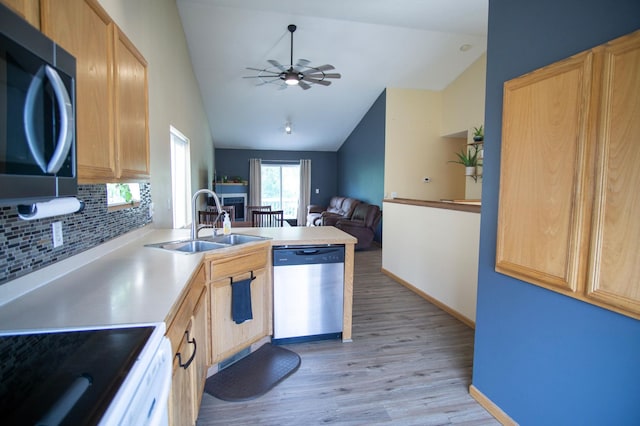 450 Meadow Ln, Somerset, WI 54025 - kitchen with stainless steel appliances, lofted ceiling, a sink, light wood-style flooring, and backsplash