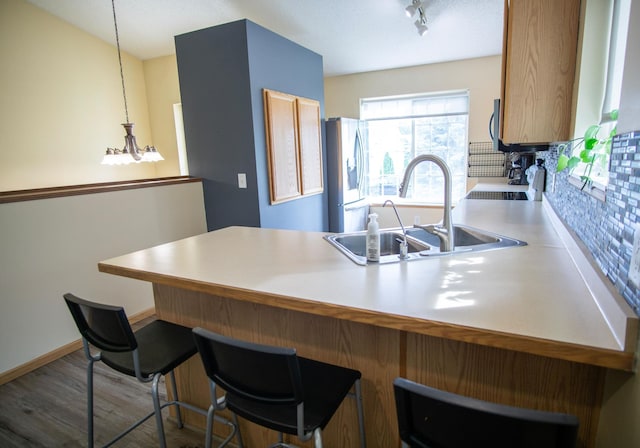 450 Meadow Ln, Somerset, WI 54025 - kitchen featuring stainless steel fridge, a sink, tasteful backsplash, a peninsula, and a kitchen breakfast bar