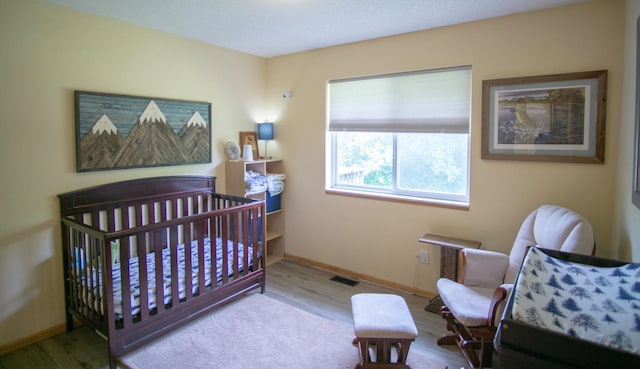 450 Meadow Ln, Somerset, WI 54025 - bedroom featuring wood finished floors, baseboards, and a crib