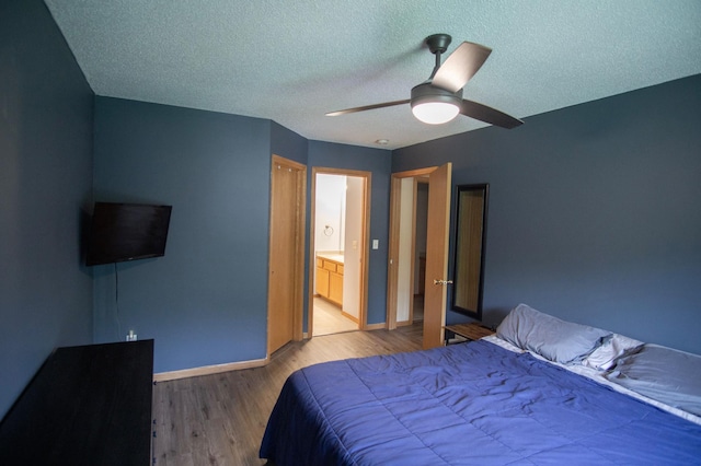 450 Meadow Ln, Somerset, WI 54025 - bedroom with wood finished floors, baseboards, a textured ceiling, a ceiling fan, and connected bathroom