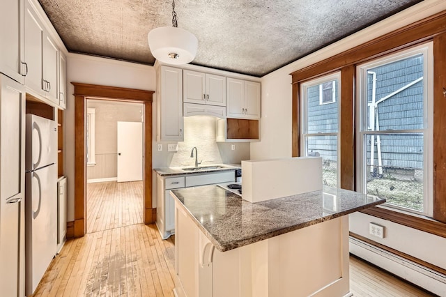 1156 Marion St, Saint Paul, MN 55117 - kitchen with a sink, a baseboard heating unit, freestanding refrigerator, light wood-style flooring, and plenty of natural light