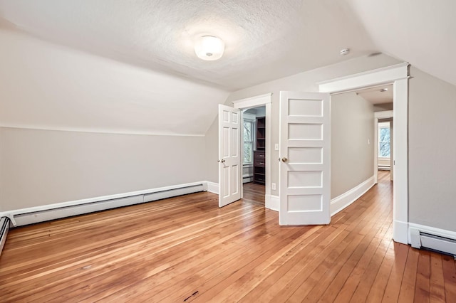 1156 Marion St, Saint Paul, MN 55117 - bonus room featuring lofted ceiling, light wood-type flooring, baseboards, a baseboard radiator, and a textured ceiling