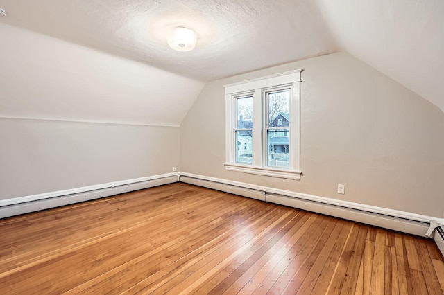 1156 Marion St, Saint Paul, MN 55117 - bonus room featuring vaulted ceiling, hardwood / wood-style floors, baseboard heating, and a textured ceiling