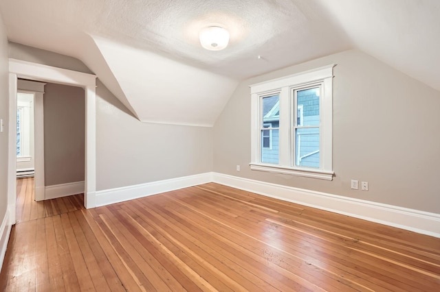 1156 Marion St, Saint Paul, MN 55117 - bonus room with baseboards, light wood-style flooring, lofted ceiling, baseboard heating, and a textured ceiling