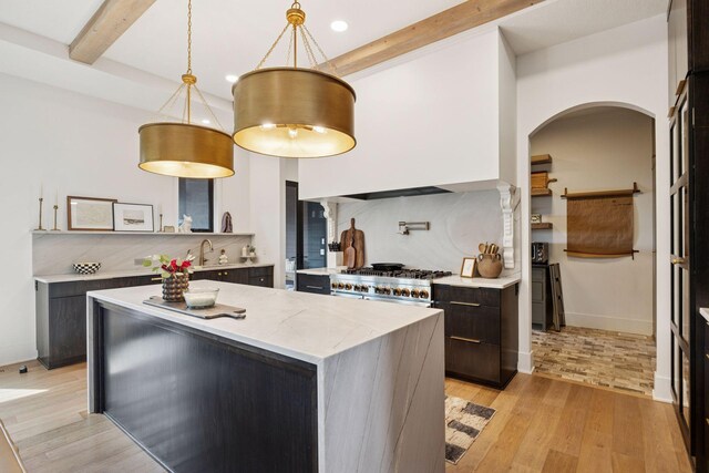 6297 Yuma Ln N, Maple Grove, MN 55311 - kitchen featuring stove, beam ceiling, backsplash, light wood-type flooring, and arched walkways