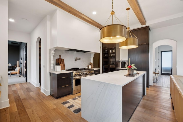 6297 Yuma Ln N, Maple Grove, MN 55311 - kitchen featuring range with two ovens, arched walkways, modern cabinets, dark brown cabinets, and beam ceiling