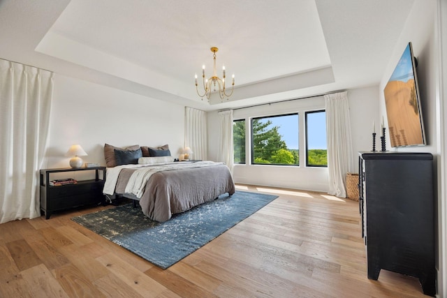 6297 Yuma Ln N, Maple Grove, MN 55311 - bedroom featuring a tray ceiling, light wood-type flooring, and a chandelier