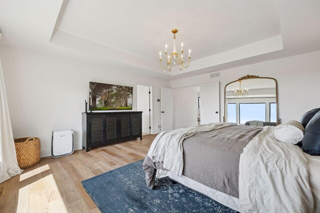 6297 Yuma Ln N, Maple Grove, MN 55311 - bedroom with a chandelier, a raised ceiling, light wood-style flooring, and baseboards