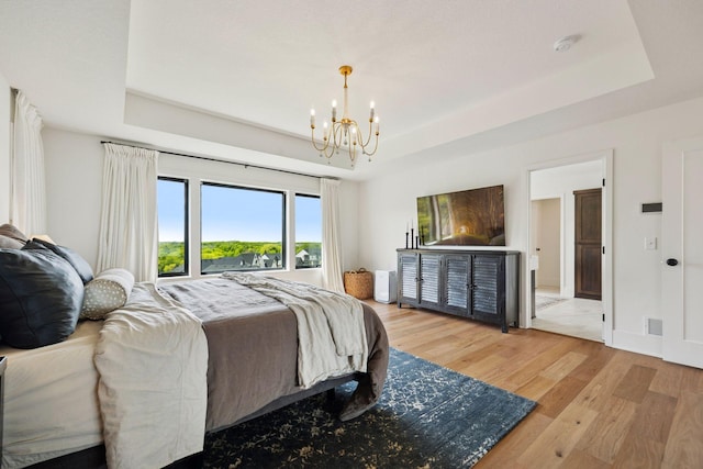 6297 Yuma Ln N, Maple Grove, MN 55311 - bedroom featuring a tray ceiling, a chandelier, and light wood finished floors