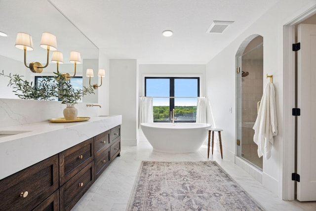 6297 Yuma Ln N, Maple Grove, MN 55311 - bathroom with double vanity, a freestanding bath, a shower stall, marble finish flooring, and baseboards