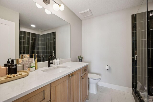 6297 Yuma Ln N, Maple Grove, MN 55311 - bathroom featuring vanity, toilet, tiled shower, baseboards, and a textured ceiling