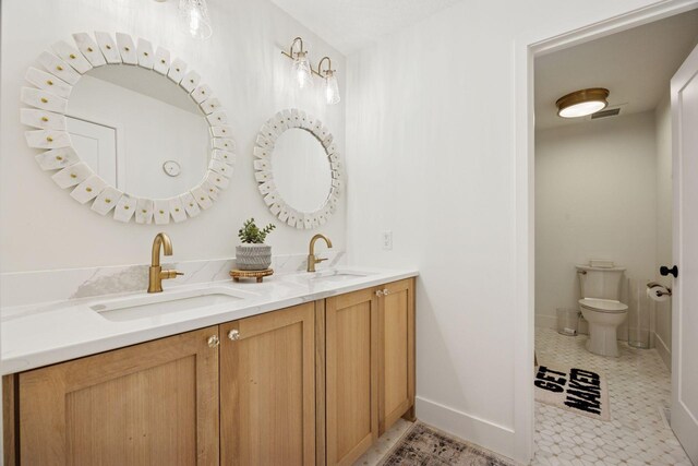 6297 Yuma Ln N, Maple Grove, MN 55311 - full bathroom with double vanity, baseboards, and toilet