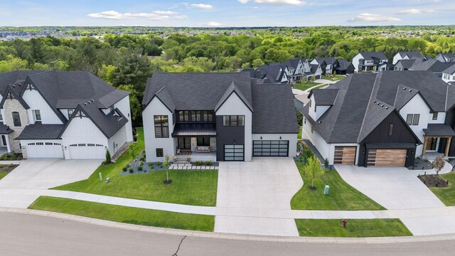 6297 Yuma Ln N, Maple Grove, MN 55311 - view of front of house featuring concrete driveway, board and batten siding, a residential view, a front lawn, and roof with shingles