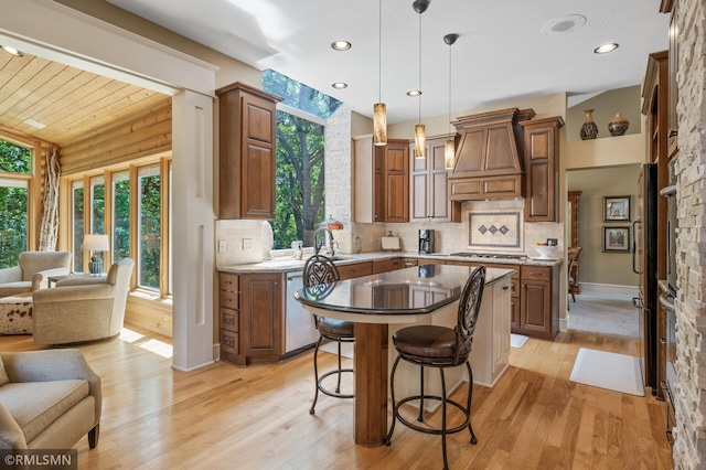 12143 Gantry Ln, Apple Valley, MN 55124 - kitchen with custom exhaust hood, open floor plan, light wood-type flooring, backsplash, and a breakfast bar