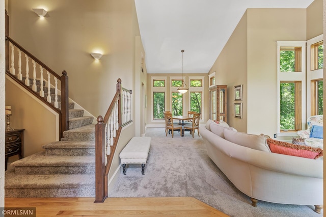 12143 Gantry Ln, Apple Valley, MN 55124 - living area featuring healthy amount of natural light, stairs, a towering ceiling, wood finished floors, and baseboards