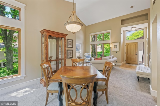 12143 Gantry Ln, Apple Valley, MN 55124 - dining room featuring high vaulted ceiling, light colored carpet, and baseboards