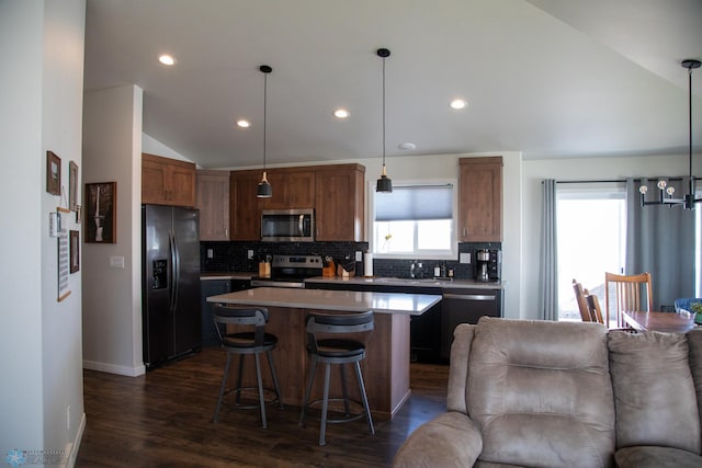 2700 14th St W, West Fargo, ND 58078 - kitchen with stainless steel appliances, lofted ceiling, open floor plan, decorative backsplash, and a kitchen island