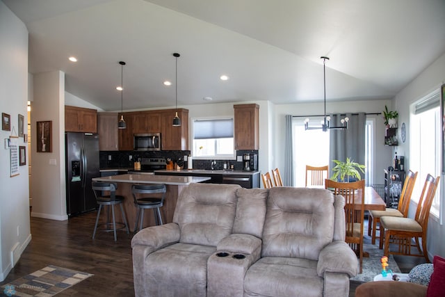 2700 14th St W, West Fargo, ND 58078 - living room featuring vaulted ceiling, healthy amount of natural light, dark wood-style flooring, a chandelier, and baseboards