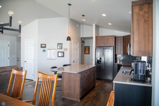 2700 14th St W, West Fargo, ND 58078 - kitchen featuring appliances with stainless steel finishes, vaulted ceiling, a center island, dark wood finished floors, and decorative backsplash