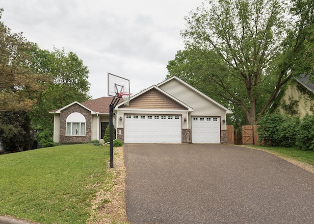 1712 Levee Ave, Anoka, MN 55303 - view of front of property featuring asphalt driveway, a garage, stone siding, and a gate