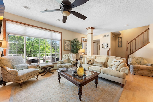 14518 Florissant Path Unit 3090, Apple Valley, MN 55124 - living area with a textured ceiling, a ceiling fan, wood finished floors, stairs, and decorative columns