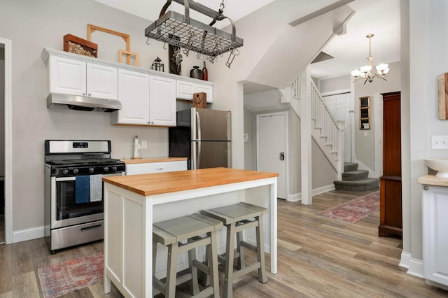 159 Western Ave S, Saint Paul, MN 55102 - kitchen with stainless steel appliances, wooden counters, under cabinet range hood, light wood-style flooring, and a chandelier