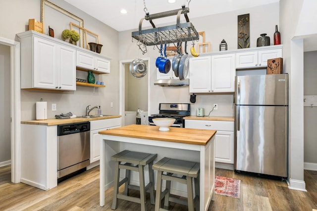 159 Western Ave S, Saint Paul, MN 55102 - kitchen featuring appliances with stainless steel finishes, wooden counters, under cabinet range hood, light wood-style flooring, and white cabinetry