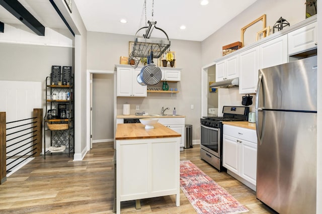 159 Western Ave S, Saint Paul, MN 55102 - kitchen with appliances with stainless steel finishes, wood counters, under cabinet range hood, open shelves, and light wood-style flooring