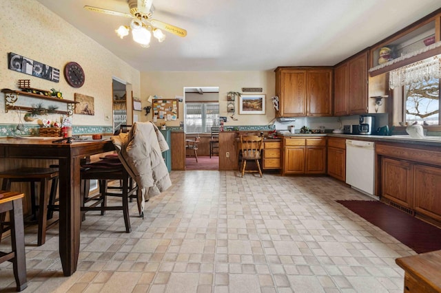 44655 Red Oak Rd, Staples, MN 56479 - kitchen with white dishwasher, brown cabinetry, and a ceiling fan